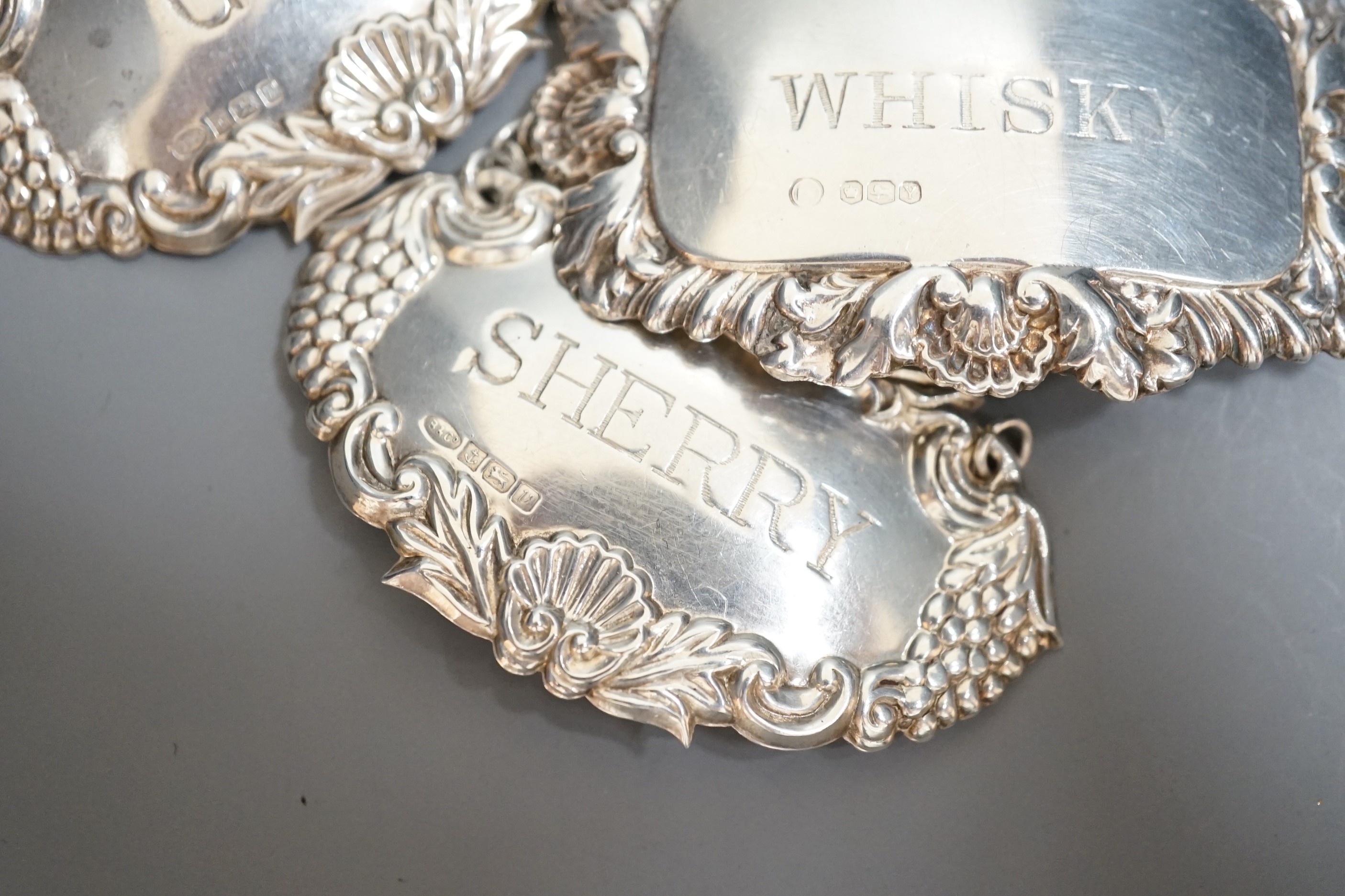 Four assorted modern silver wine labels including enamelled Sherry.